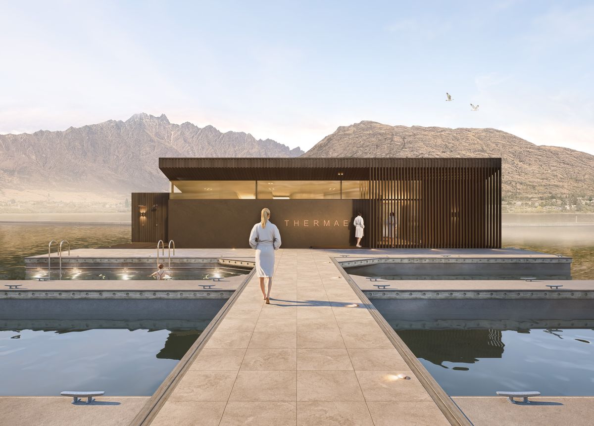 Thermae entrance deck at dawn, timber and glass pavilion with lake pools, The Remarkables beyond
